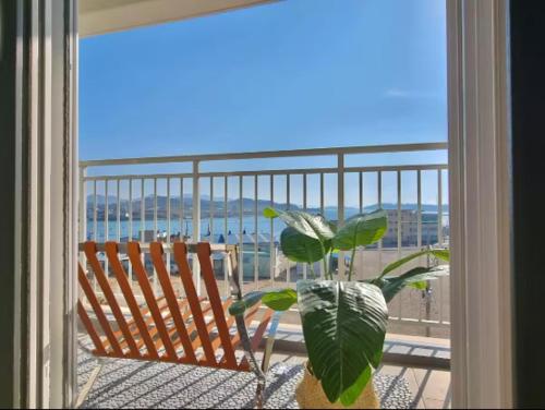 a plant sitting on a balcony with a view of the ocean at Yeosu U-Bless Terrace Ocean View in Yeosu