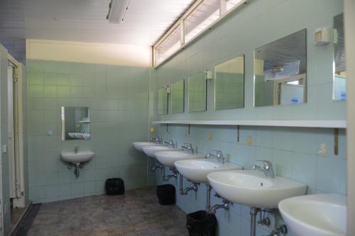 a bathroom with a row of sinks and mirrors at Camping Vigna di Valle in Anguillara Sabazia