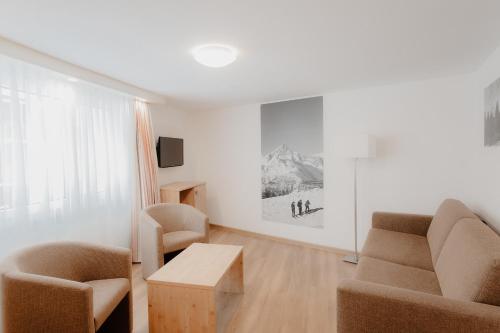 a living room with a couch and two chairs and a table at Lifestyle & Spa Hotel Grächerhof in Grächen
