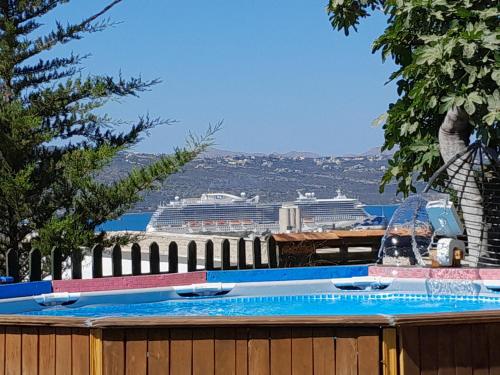a swimming pool with a cruise ship in the background at Michaela's House in Tsikalariá