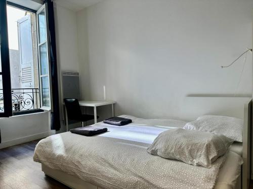 une chambre avec un lit, un bureau et une fenêtre dans l'établissement Dolaizon 1 - Studio Meublé 28 m2, au Puy-en-Velay