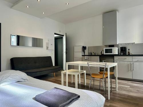 une chambre avec un lit et une table et une cuisine dans l'établissement Dolaizon 1 - Studio Meublé 28 m2, au Puy-en-Velay