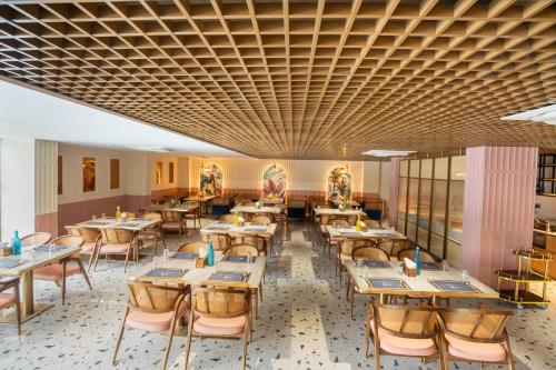 a restaurant with tables and chairs in a room at Trunk and Trolley , A Luxury Boutique Hotel, Gachibowli, Hyderabad in Hyderabad