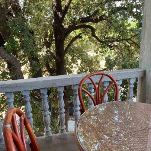two chairs and a table on a balcony at Apartmani Vilastija in Utjeha