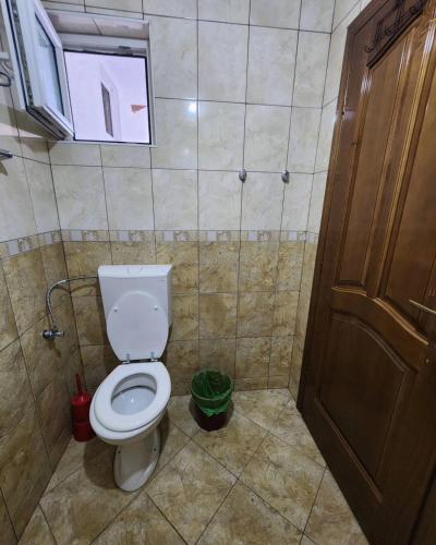 a bathroom with a toilet and a window and a door at Apartmani Vilastija in Utjeha