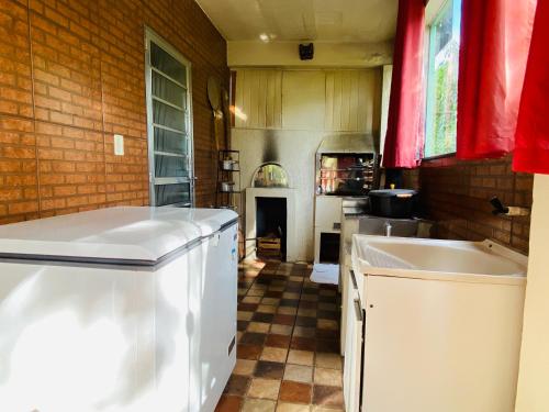 a kitchen with a counter and a sink in it at Cantinho da Mariazinha em Penedo in Penedo