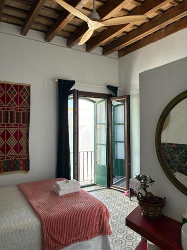 a bedroom with a bed and a large window at Doña Lola Rooms in Conil de la Frontera