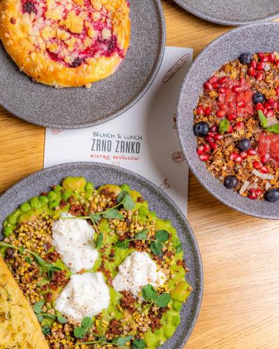 a table with three plates of food and a pizza at R16 Residences Prague in Prague