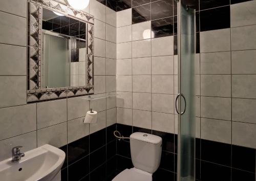 a bathroom with a toilet and a sink and a mirror at Bohema Restauracja i Noclegi in Supraśl