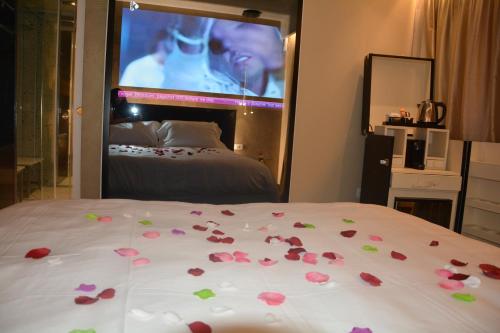 a bedroom with roses on a bed with a tv at Alba Suites in Vlorë