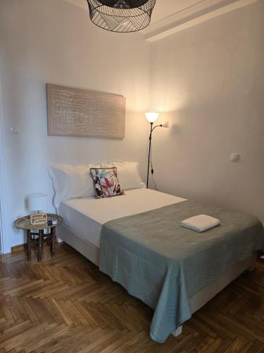 a small bedroom with a bed and a table at Down town in Athens