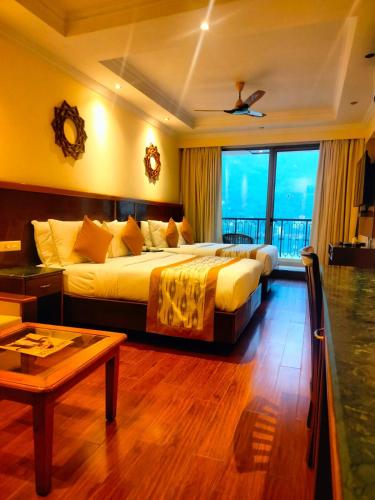 a hotel room with two beds and a table at Divine Resort & Spa in Rishīkesh
