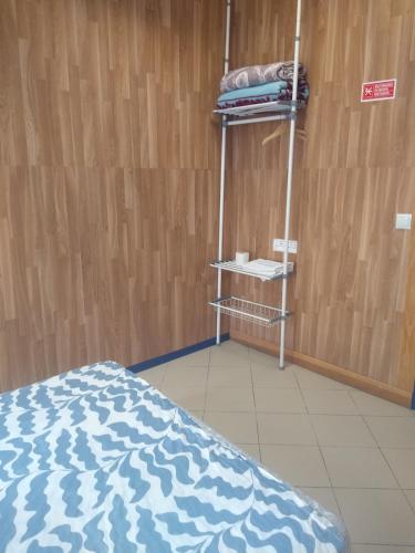 a room with a bed and a shelf with towels at Melaya Budget Hostel in Faro