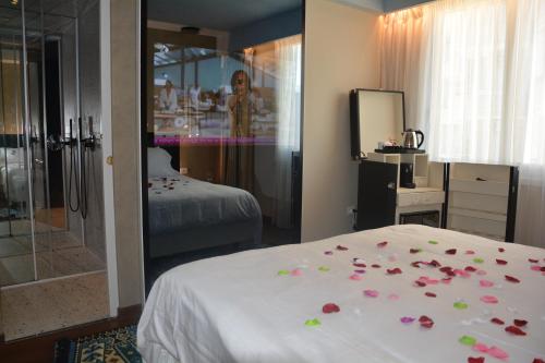 a bedroom with roses on a bed and a mirror at Alba Suites in Vlorë
