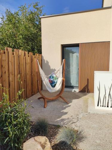 a hammock sitting in a yard next to a fence at Invitation Bord de mer à Portbail in Port-Bail-sur-Mer