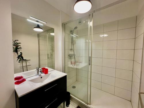 une salle de bain avec lavabo et douche dans l'établissement La mouette rieuse, terrasse, vue mer, accès plage, à Bernières-sur-Mer