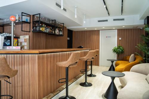 a bar in a restaurant with stools at Hotel Mefolinkel Suits in Lloret de Mar