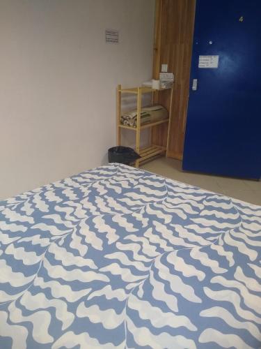 a bedroom with a bed with a blue and white comforter at Melaya Budget Hostel in Faro