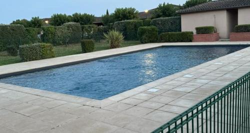 une piscine avec de l'eau bleue dans une cour dans l'établissement Le Refuge Zen, à Fenouillet