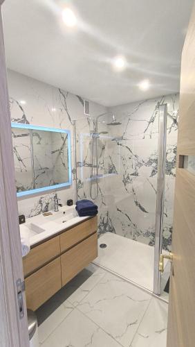 une salle de bain avec un lavabo et une douche dans l'établissement Royal Lux Spacious seaside pool, à Nice
