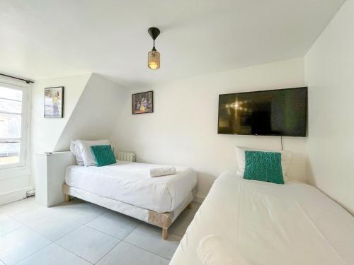 une chambre avec deux lits et une télévision à écran plat dans l'établissement 144 - Urban Charming Studio in Paris, à Paris