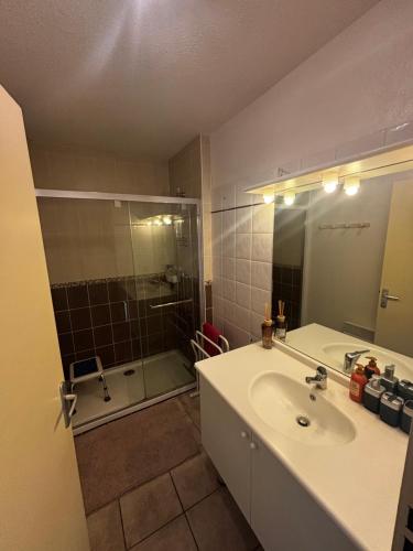a bathroom with a sink and a shower and a tub at Appartement climatisé Résidence Goélia Les Jardins De Phoebus in Gruissan