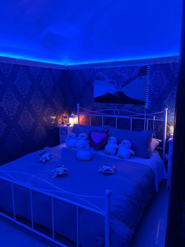 two teddy bears sitting on a bed with blue lights at Donna Margherita Appartamento in Naples