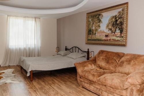 a living room with a couch and a bed at Golden park Apartments in Umanʼ
