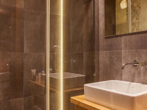 un bagno con lavandino e doccia in vetro di Studio montagnard avec balcon, vue montagnes et accès bien-être - FR-1-467-38 a Le Grand-Bornand