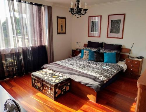a bedroom with a large bed with blue pillows at Spacious apartment with stunning harbour view in Sydney