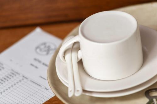 a white coffee cup on a plate on a table at Hotel Naka in Diego Suarez