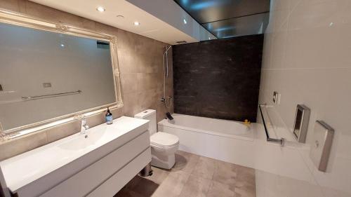 a bathroom with a tub and a toilet and a sink at Spacious apartment with stunning harbour view in Sydney