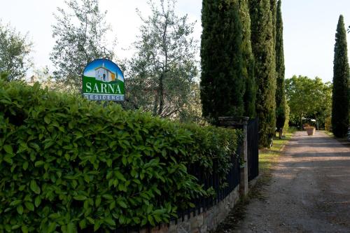 a sign on a hedge next to a fence at SARNA Residence in San Quirico dʼOrcia