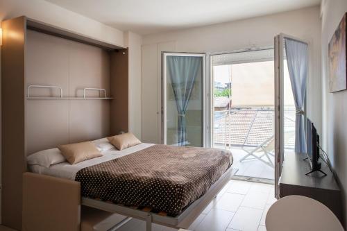a bedroom with a bed and a sliding glass door at Residence Sunrise in Cesenatico