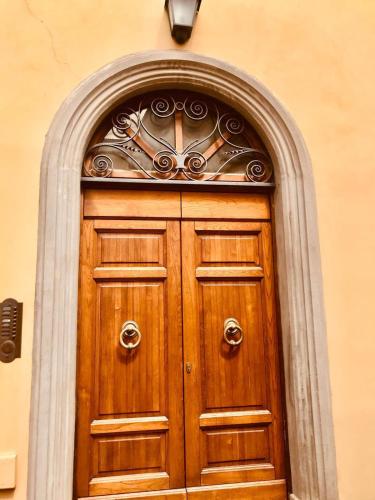 a wooden door with an arch above it at La Fattoria - centro storico in Campagnatico