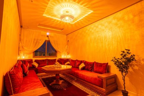 a living room with a red couch and a table at HAGS Apartment - Traditional Modern Apartment, full AC, 10m from airport in Marrakech