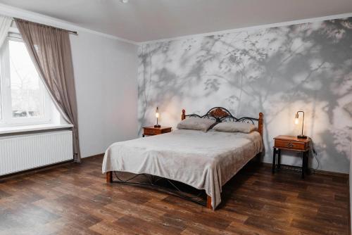 a bedroom with a bed and a wall with flowers at Golden park Apartments in Umanʼ