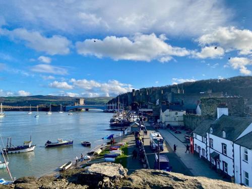 a group of boats are docked in a river at Morfarch traditional stone cottage within Conwy walls in Conwy