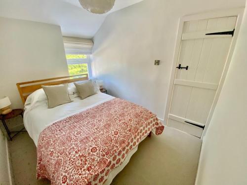 a bedroom with a bed and a window and a door at Morfarch traditional stone cottage within Conwy walls in Conwy