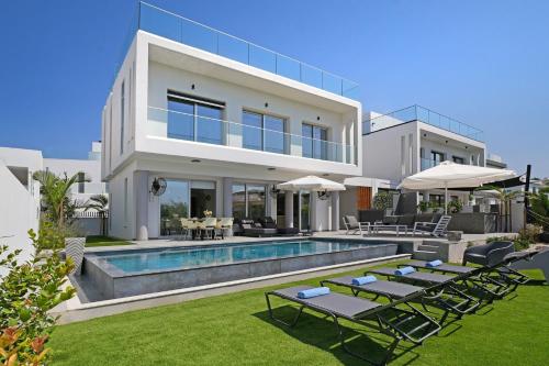 a villa with a swimming pool and lawn at MAREN - 250m from Golden Sandy Beach in Paralimni