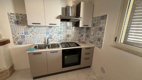 a small kitchen with a sink and a stove at Villa thomas torre vado san Gregorio in Marina San Gregorio
