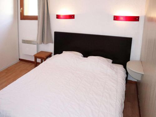 - une chambre avec un lit blanc et deux lumières au-dessus dans l'établissement Appartement avec piscine, sauna et hammam aux Orres 1800 - 4 pers - FR-1-322-75, aux Orres