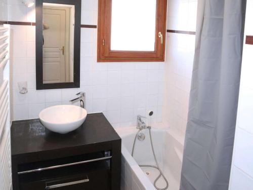 une salle de bain avec un lavabo, un miroir et une baignoire dans l'établissement Appartement avec piscine, sauna et hammam aux Orres 1800 - 4 pers - FR-1-322-75, aux Orres