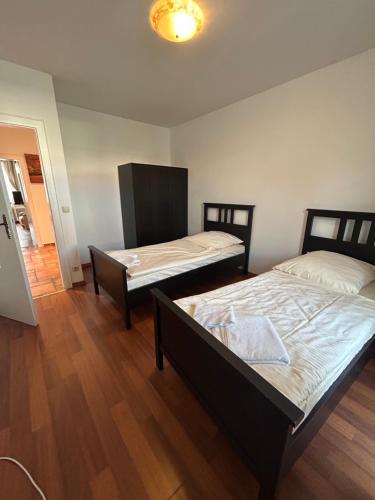 two beds in a room with wooden floors at City Lodge Hannover in Hannover