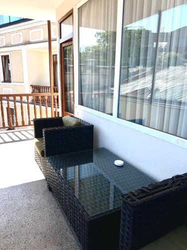 a screened in porch with two chairs and a glass table at Hotel New Terrace in Tbilisi City