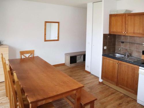 Il comprend une cuisine avec une table en bois et un évier. dans l'établissement Les Orres 1800: Appart 3 pièces, Piscine, WiFi, Animaux admis - FR-1-322-431, aux Orres