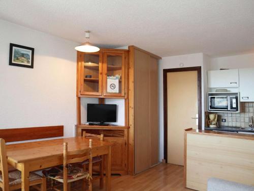 - une cuisine et une salle à manger avec une table et un four micro-ondes dans l'établissement Studio lumineux au cœur de la station avec balcon - FR-1-322-571, aux Orres