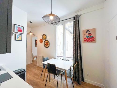 une cuisine et une salle à manger avec une table et des chaises dans l'établissement 146 - Urban Cosy Flat in Paris, à Paris