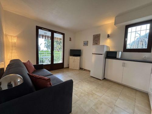 un salon avec un canapé et une cuisine dans l'établissement Studio climatisé avec parking face à la mer - 2 couchages - FR-1-226B-233, à Cavalaire-sur-Mer