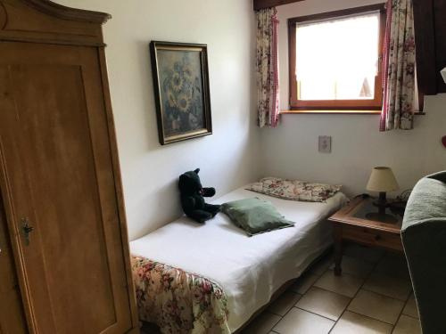 a teddy bear sitting on a bed in a room at Haus Bachschwalbe in Sasbachwalden